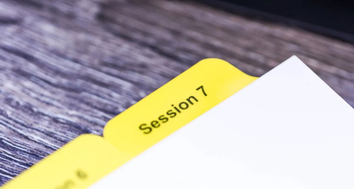 Close-up of Mylar film reinforcing a printed index tab extension — the tab coating step performed in-house at Anselmo Die & Index, Schaumburg IL