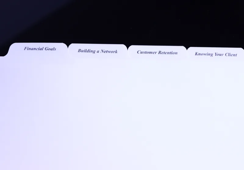 Printed advisor binder tabs reading Financial Goals, Building a Network, Customer Retention and Knowing Your Client — custom index tabs by Anselmo Die & Index