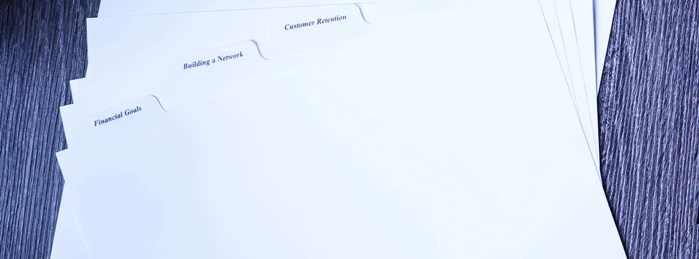 Index tab dividers with clear Mylar tabs printed with client section titles, fanned to show each tab position — private-label tab sets die-cut, printed and collated by Anselmo Die & Index