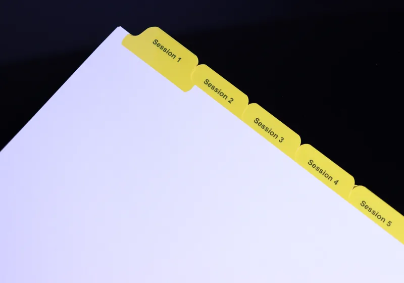 Sequential yellow Mylar index tabs printed Session 1 through Session 5 — step-indexed training manual tab set by Anselmo Die & Index